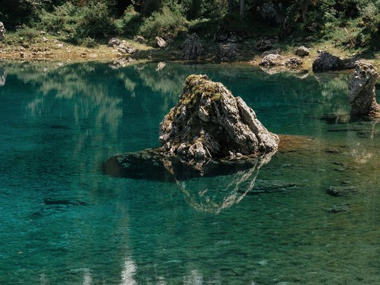 Offers – holidays in the Dolomites UNESCO World Heritage Clear lake with rocks and reflections of trees in the water
