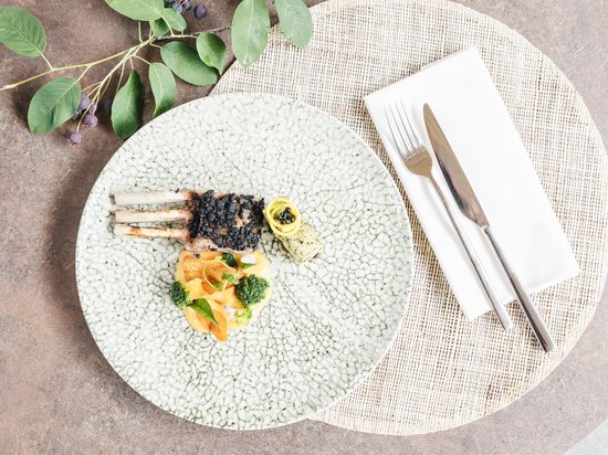 Places of energy, divine flavours: Anima restaurant Gourmet dish with lamb chops, vegetables, and decorative cutlery