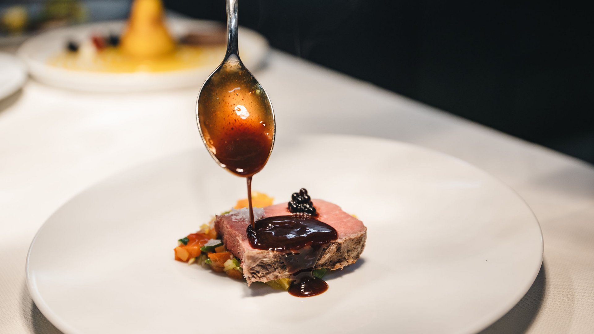 South Tyrolean recipes. Reinterpreted. Sauce poured on a slice of pink cooked meat with vegetables