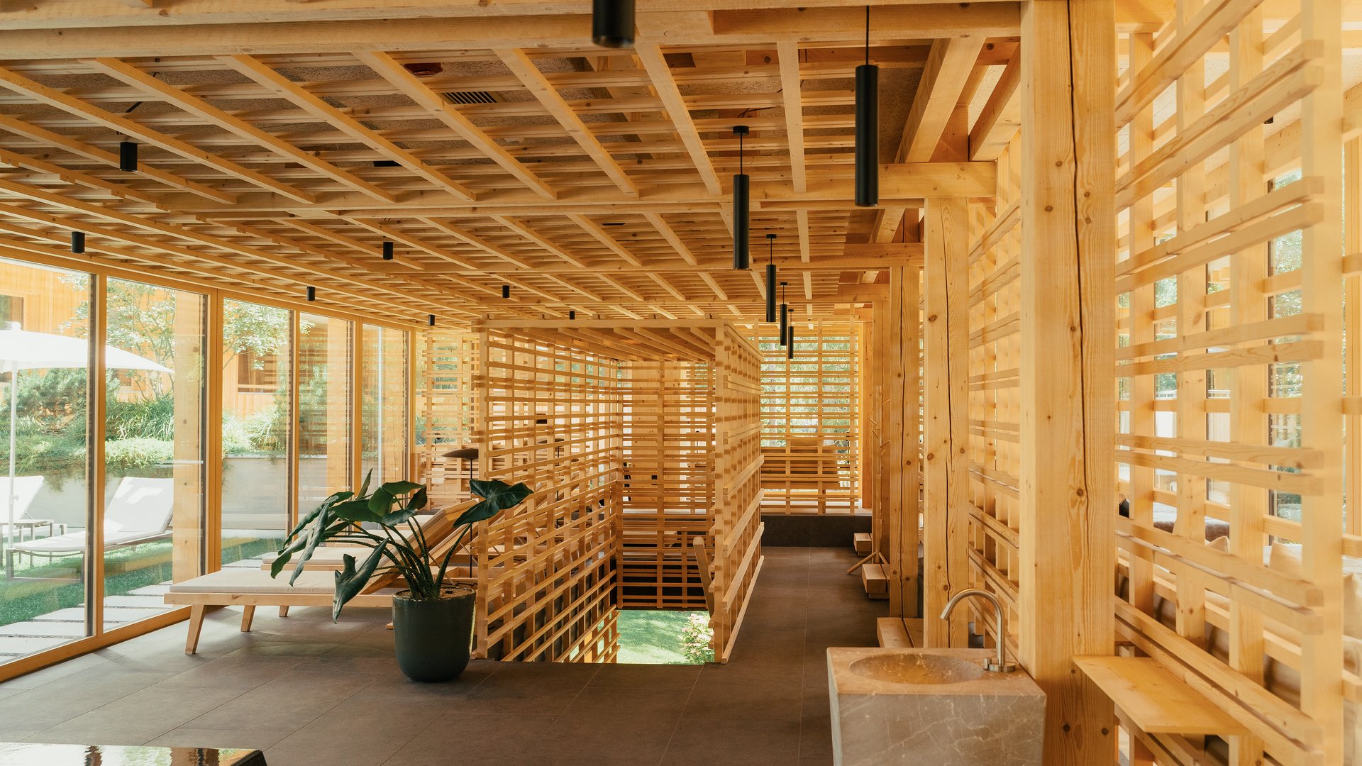 Hotel all’Alpe di Siusi con piscina: lusso per l’anima Interno luminoso con lamelle di legno, finestre e piante