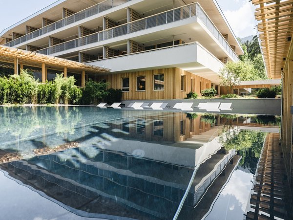 Wellness Aphrodite: Sensoria Dolomites among the winners Modern hotel with pool and lounge chairs, reflection in water