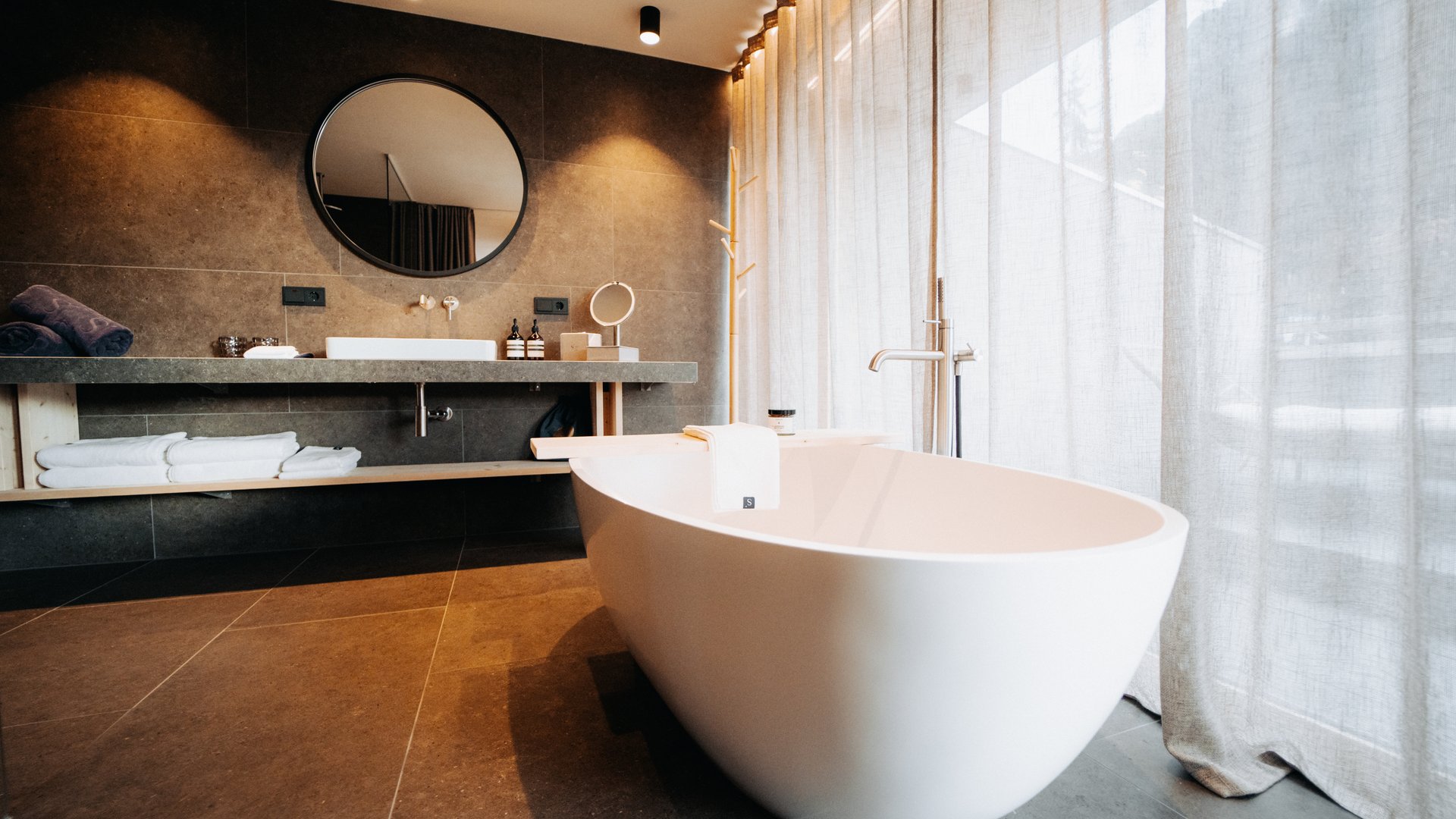 Sensoria: Private Spa Suite mit Whirlpool in Südtirol Moderner Badezimmer mit freistehender Badewanne und rundem Spiegel