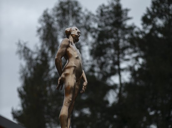 Sensoria Art Edition Bronzestatue einer Frau auf einem Dach vor bewölktem Himmel