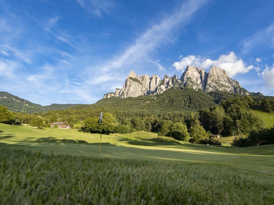 Vacanza e golf: accoppiata vincente Campo da golf con montagne e cielo azzurro sullo sfondo