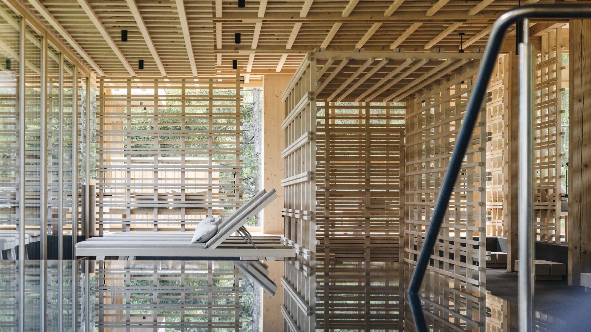 Das Badehaus im Hotel mit Pool in den Dolomiten Innenraum eines Spa mit Holzgestaltung und Liegestühlen am Pool