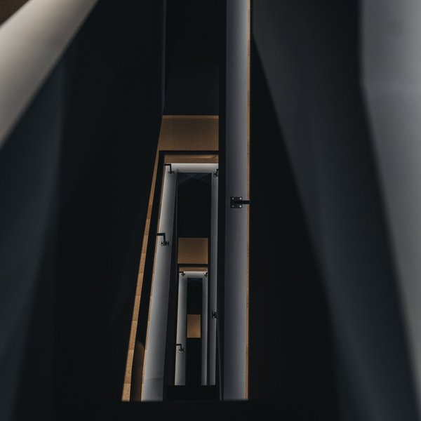 Sensoria Dolomites: Wellnesshotel in den Dolomiten Blick in ein modernes, dunkles Treppenhaus mit mehreren Etagen