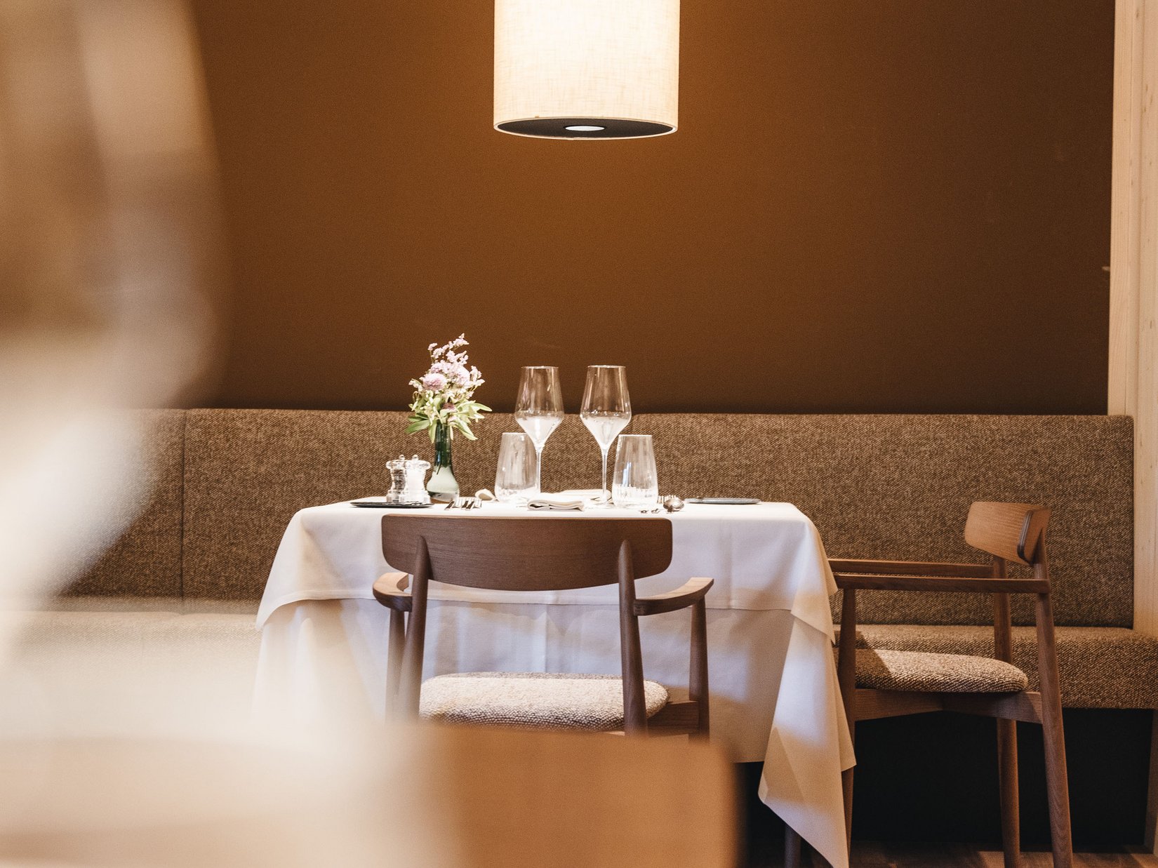Sensoria Dolomites: hotel in montagna Tavolo apparecchiato romanticamente con decorazione floreale e lampada a sospensione