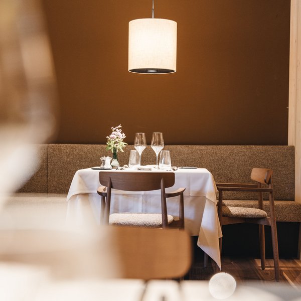 Sensoria Dolomites: Wellnesshotel in den Dolomiten Romantisch gedeckter Esstisch mit Blumendekor unter Hängelampe