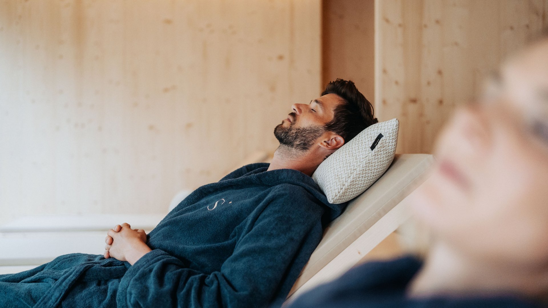 A day spa in the Dolomites to soothe your soul Man relaxing on lounge chair with closed eyes and pillow in spa