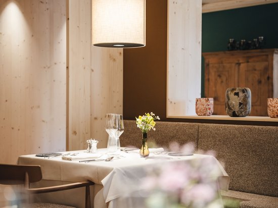 Sensoria Dolomites: Wellnesshotel in den Dolomiten Gemütlicher Restauranttisch mit weißer Tischdecke und Blumenvase