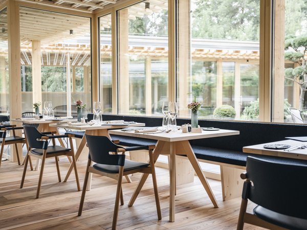 Wellness Aphrodite: Sensoria Dolomites among the winners Modern restaurant with wooden furniture and large windows overlooking the garden