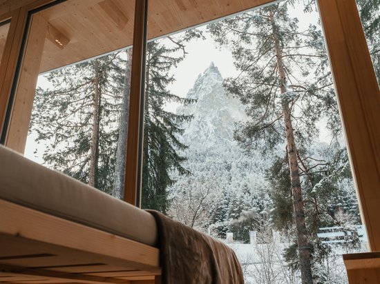 Wellness on Alpe di Siusi/Seiser Alm – Sensoria Dolomites View from wooden room of snowy mountain and forest