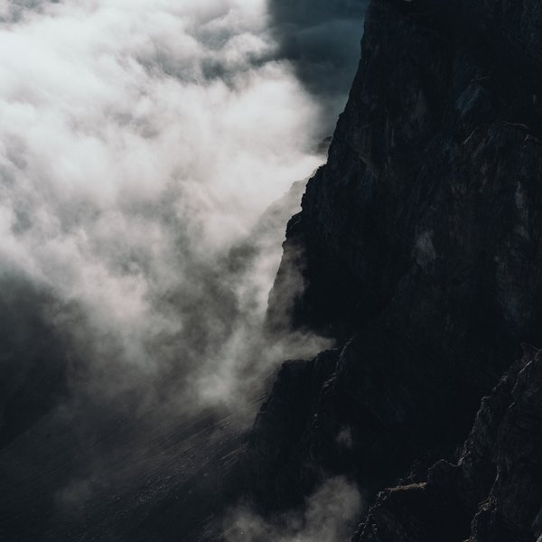 Sustainability at Sensoria Dolomites Dark rocky cliff with fog or clouds in the mountains