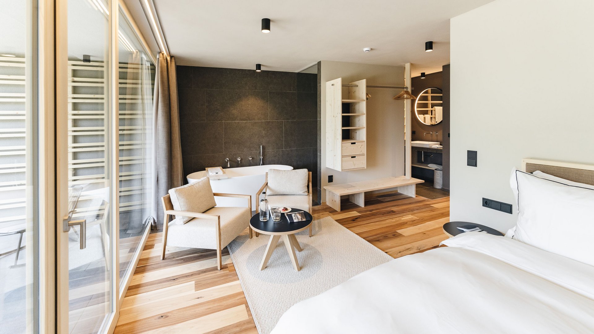 Sensoria Dolomites: il vostro hotel sull’Alpe di Siusi Camera d'hotel moderna con vasca, zona salotto e grande finestra