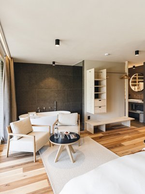 Sensoria Dolomites: il vostro hotel sull’Alpe di Siusi Camera d'hotel moderna con vasca, zona salotto e grande finestra