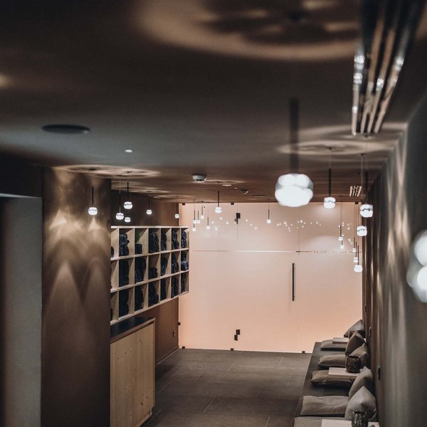 Sensoria Dolomites: Wellnesshotel in den Dolomiten Dunkler Flur mit Sitzbank und Regalen in gemütlichem Spa-Bereich