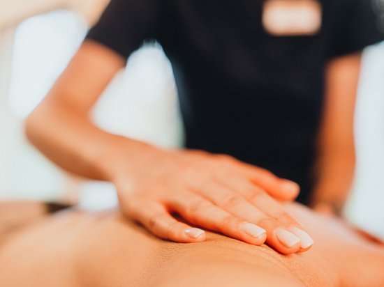 Sensoria Dolomites: Babymoon in Südtirol Nahaufnahme einer Hand bei einer Massage auf dem Rücken