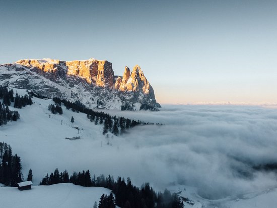 Settimana bianca sulle Dolomiti, al Sensoria Dolomites Montagne innevate al tramonto con nebbia nella valle