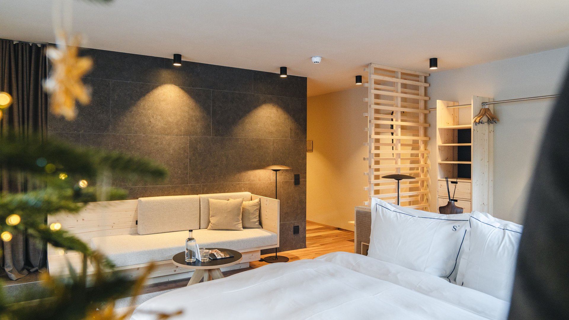 Place of spiritual energy – your favourite room Cozy hotel room with bed, sofa, and decorated Christmas tree