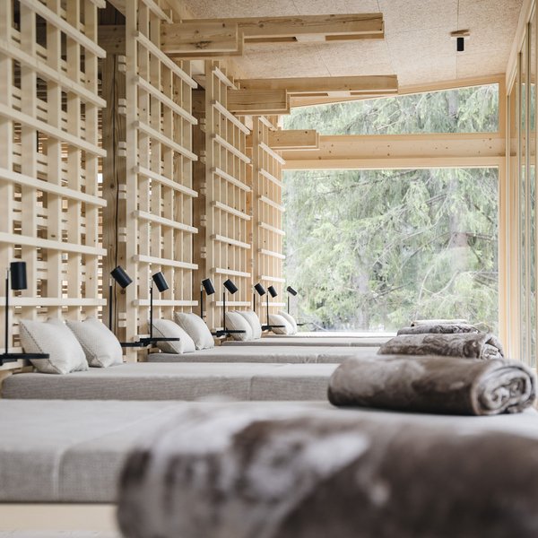 Sensoria Dolomites: Flitterwochen in Südtirol Modernes Spa-Wartezimmer mit Holzstruktur und Liegen mit Kissen