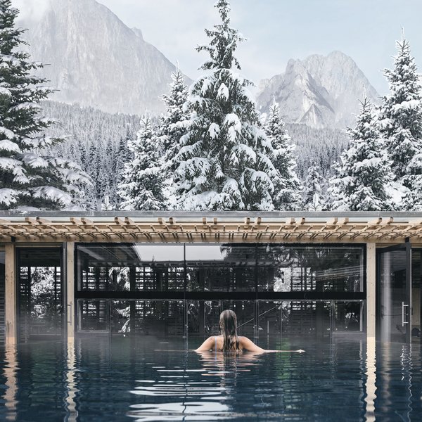 Sensoria Dolomites: il vostro hotel sull’Alpe di Siusi Persona in piscina con vista su abeti innevati e montagne
