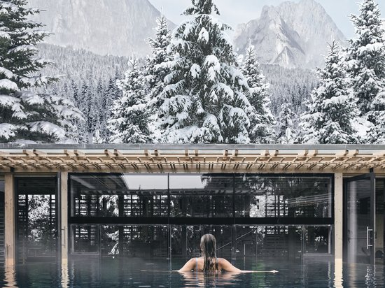 Sensoria Dolomites: hotel in montagna Persona in piscina con vista su abeti innevati e montagne