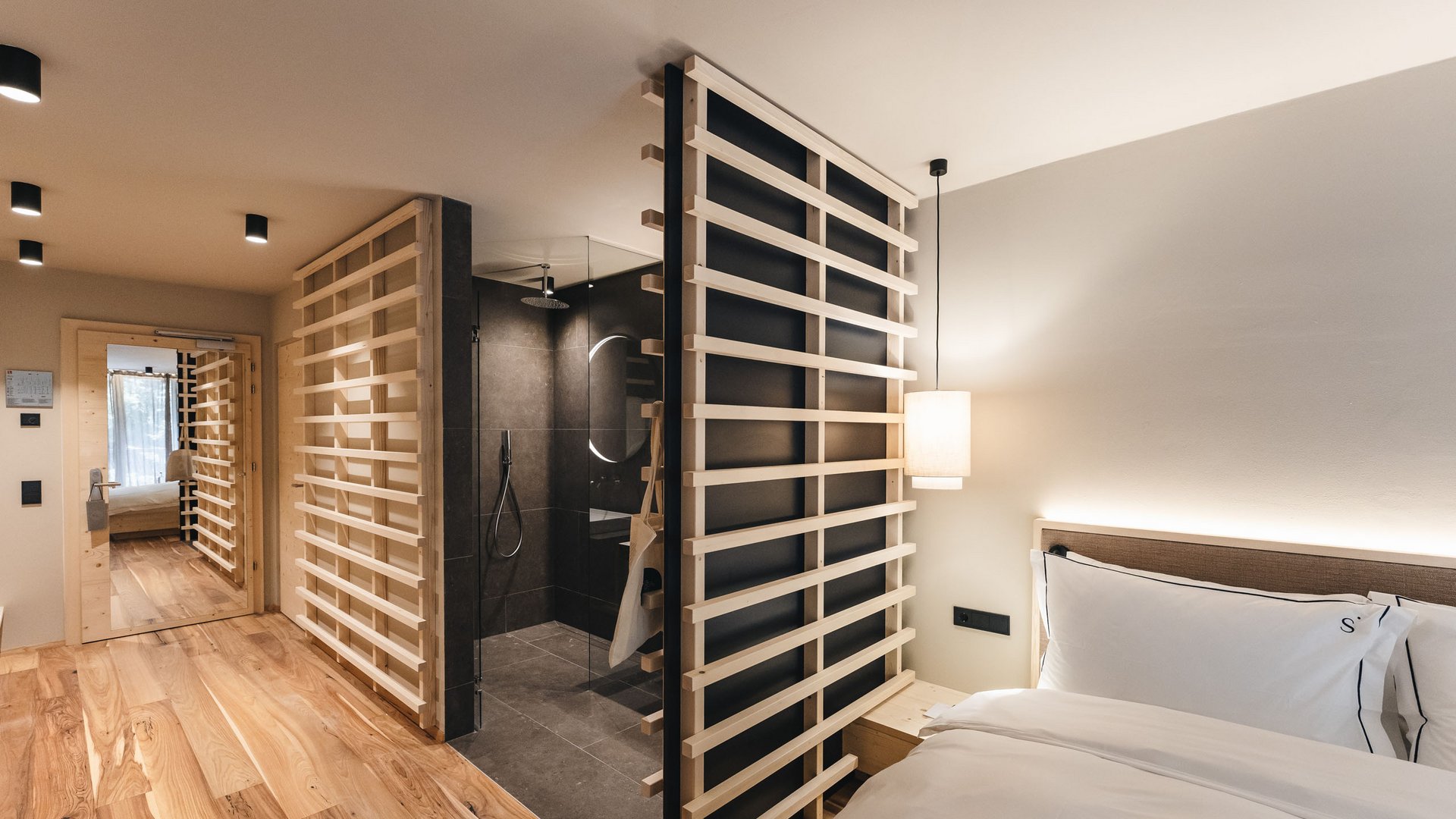 Dormire a Siusi allo Sciliar: la vostra camera preferita Camera d'albergo moderna con elementi in legno e doccia a vista