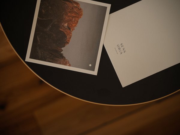 Soggiorno all’Alpe di Siusi: info da scaricare Foto e cartolina su tavolo rotondo con scritto Sens Oria Dolomites