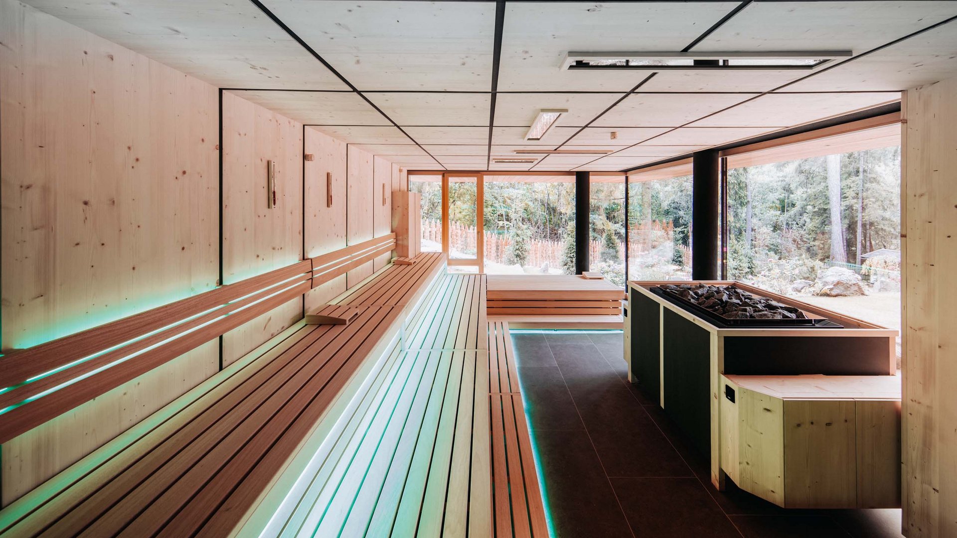 A day spa in the Dolomites to soothe your soul Modern sauna room with large windows and wooden benches