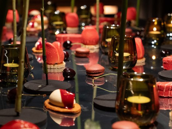 Sensoria Art Edition Nahaufnahme von roten und weißen Dessertstücken auf einem Tisch mit grünen Stielen