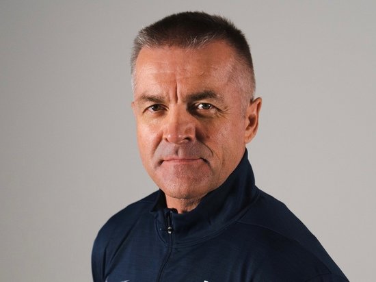 My Olympic Mindset Retreat 2026 Ritratto di un uomo con giacca sportiva blu scuro su sfondo grigio