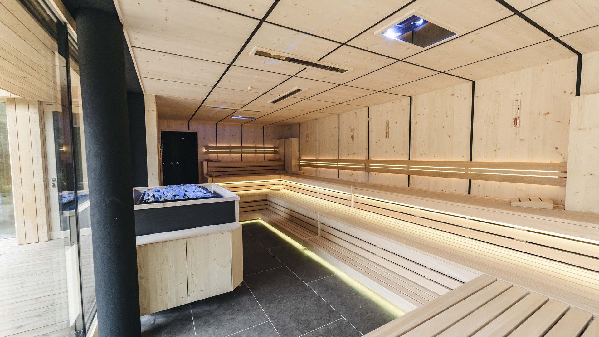 Das Badehaus im Hotel mit Pool in den Dolomiten Moderne finnische Sauna mit Holzverkleidung und integriertem Ofen