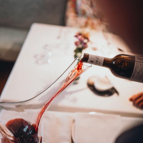 Sensoria Dolomites: il vostro hotel sull’Alpe di Siusi Vino rosso versato in una caraffa sopra un tavolo bianco con tovaglioli