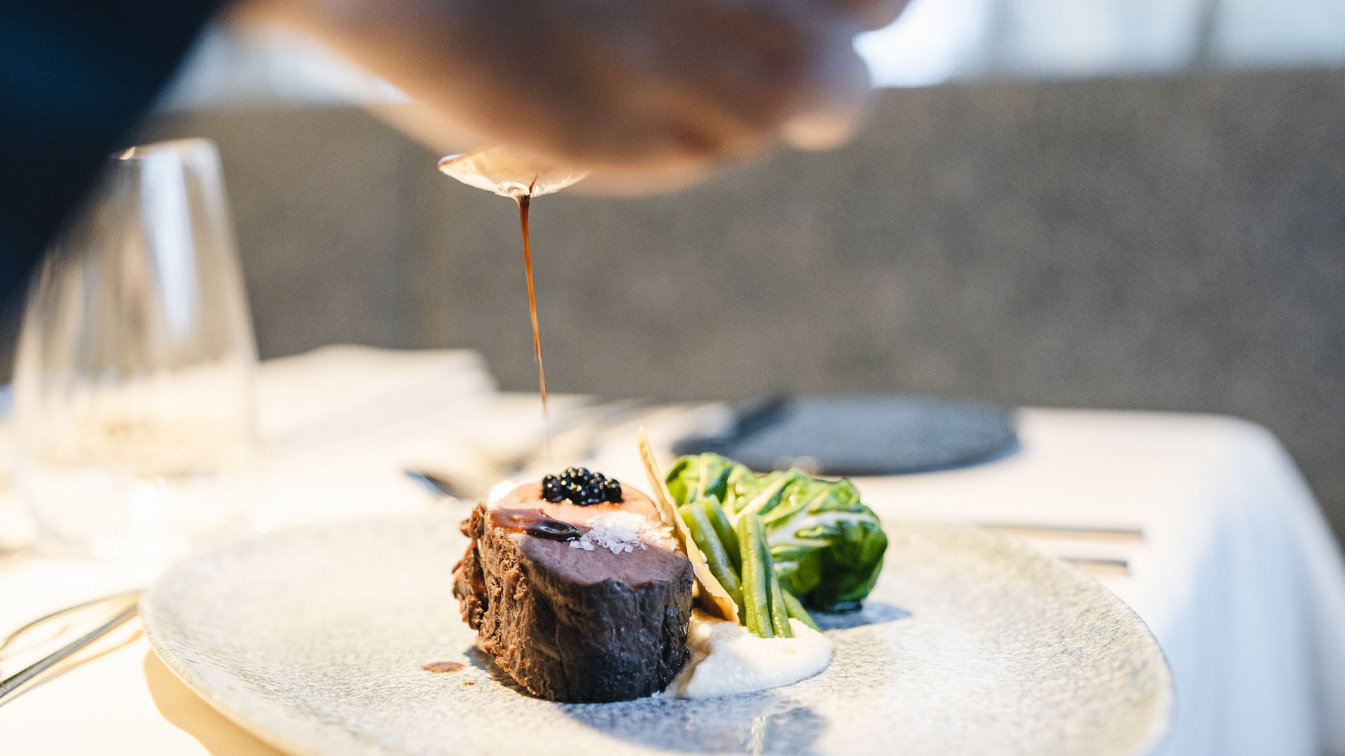 Sensoria Dolomites: Wellnesshotel in den Dolomiten Filetsteak mit Soße, grünem Gemüse und Sauce auf Teller