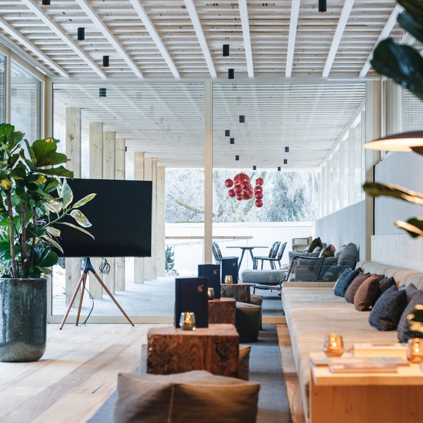 Sensoria Dolomites: il vostro hotel sull’Alpe di Siusi Zona lounge moderna con soffitto in legno, divani e grandi finestre