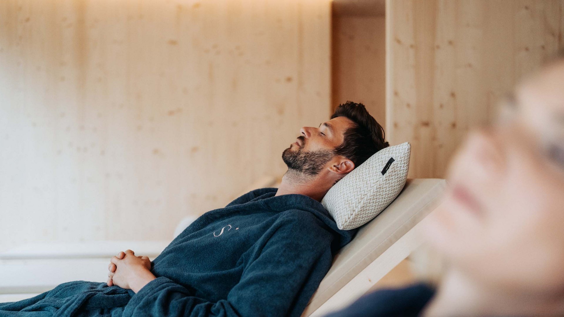 Sensoria Dolomites: il vostro hotel sull’Alpe di Siusi Uomo rilassato in accappatoio su sdraio con cuscino per la testa
