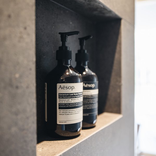 Romantischer Kurzurlaub für Verliebte – Sensoria Dolomites Zwei Flaschen Aesop Körperreinigungs-Gel im Regal aus Stein