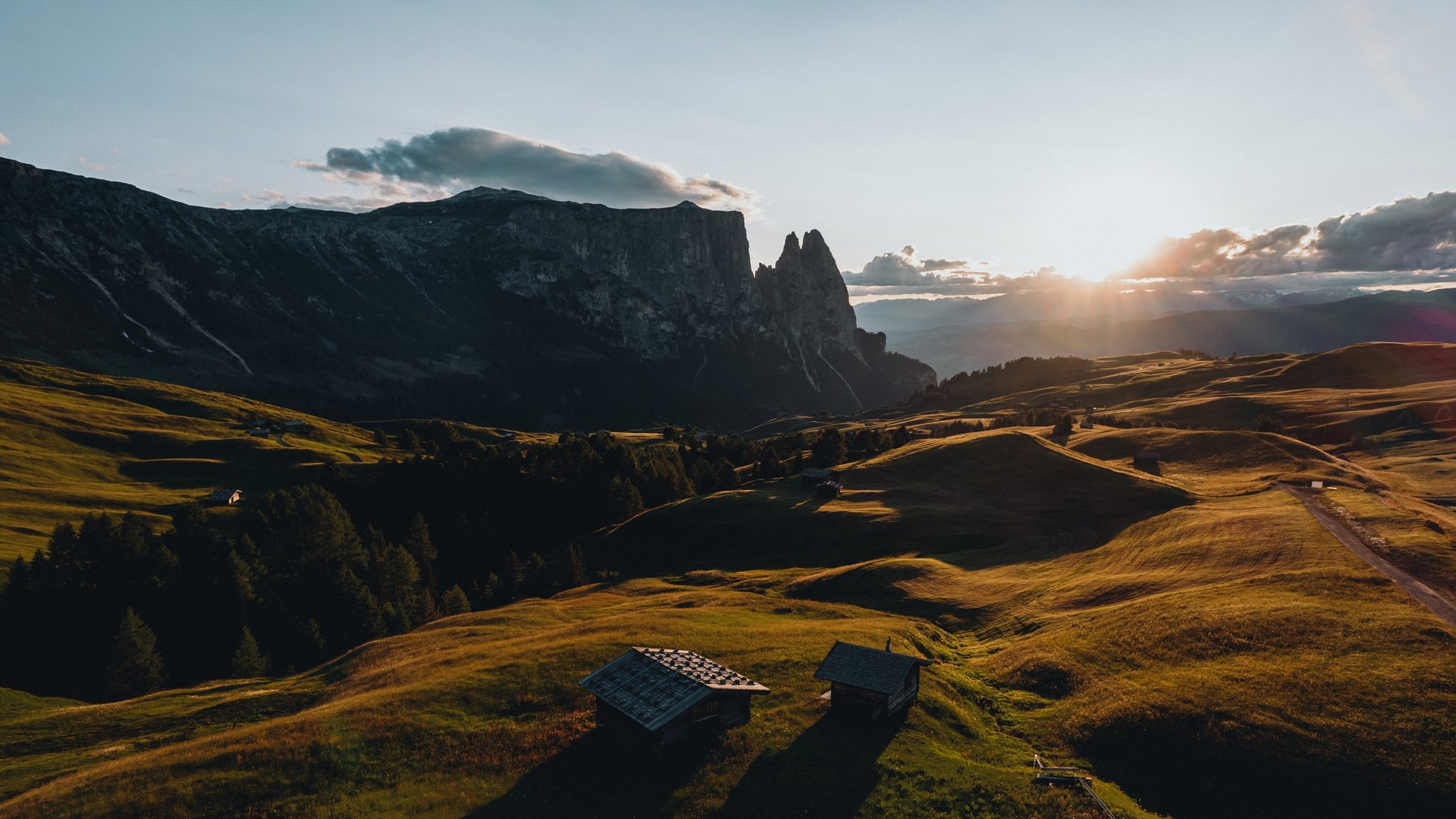 Holidays in the Dolomites – holidays at Sensoria Dolomites Sunset over green hills with mountains in the background