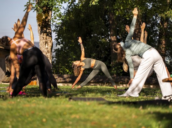 Alpe di Siusi Balance: in armonia con la natura Gruppo che fa yoga all'aperto su un prato sotto gli alberi