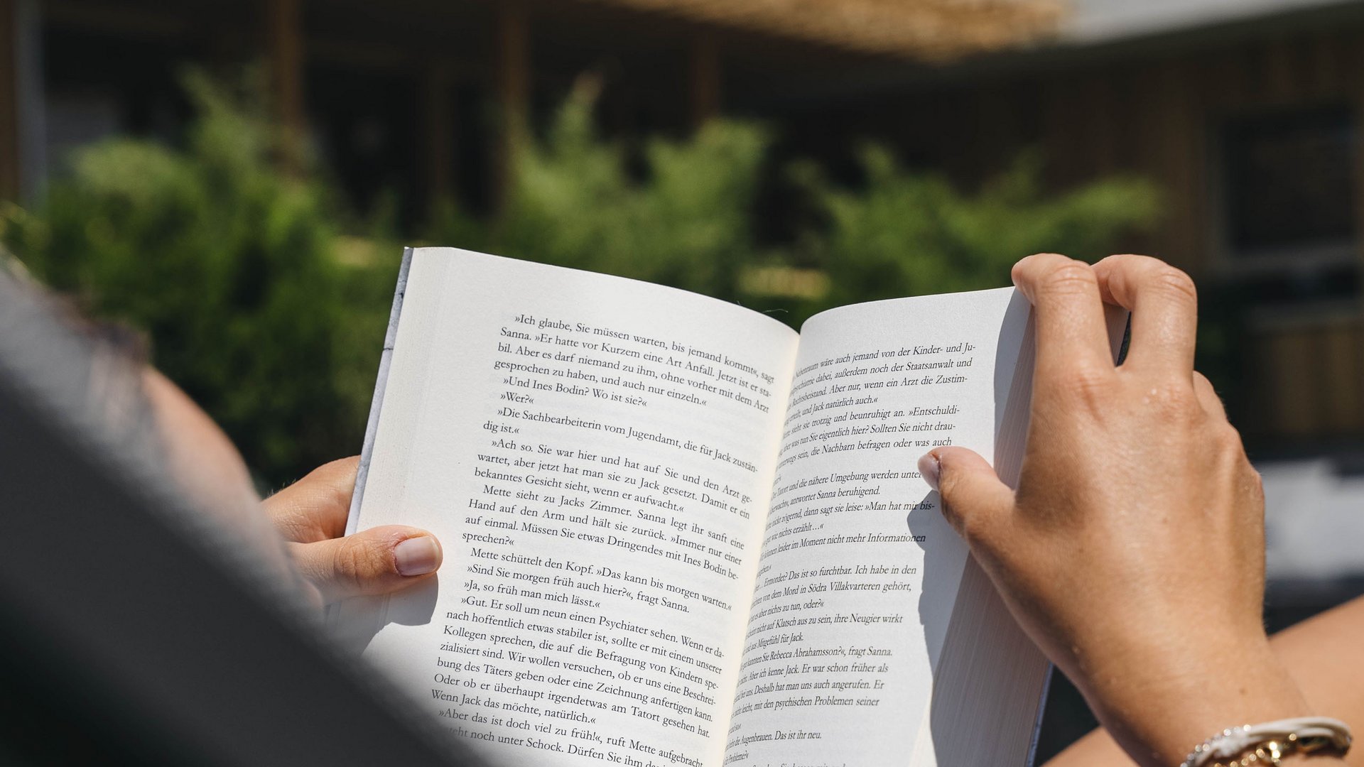 Sensoria Dolomites: Babymoon in Südtirol Person liest Buch im Freien auf einer Liege bei Sonne