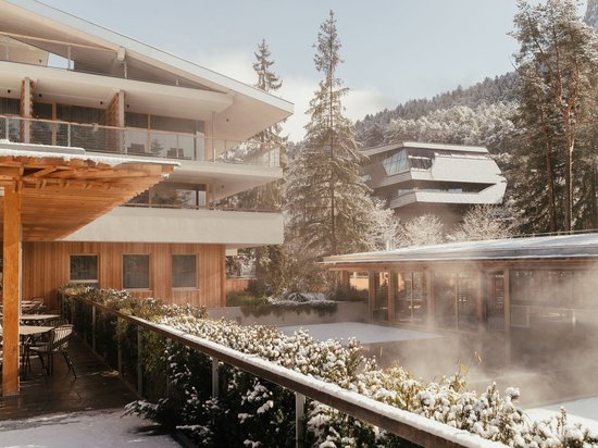 Hotel all’Alpe di Siusi: un tempio di energia per l’anima Hotel innevato con terrazza e montagne sullo sfondo