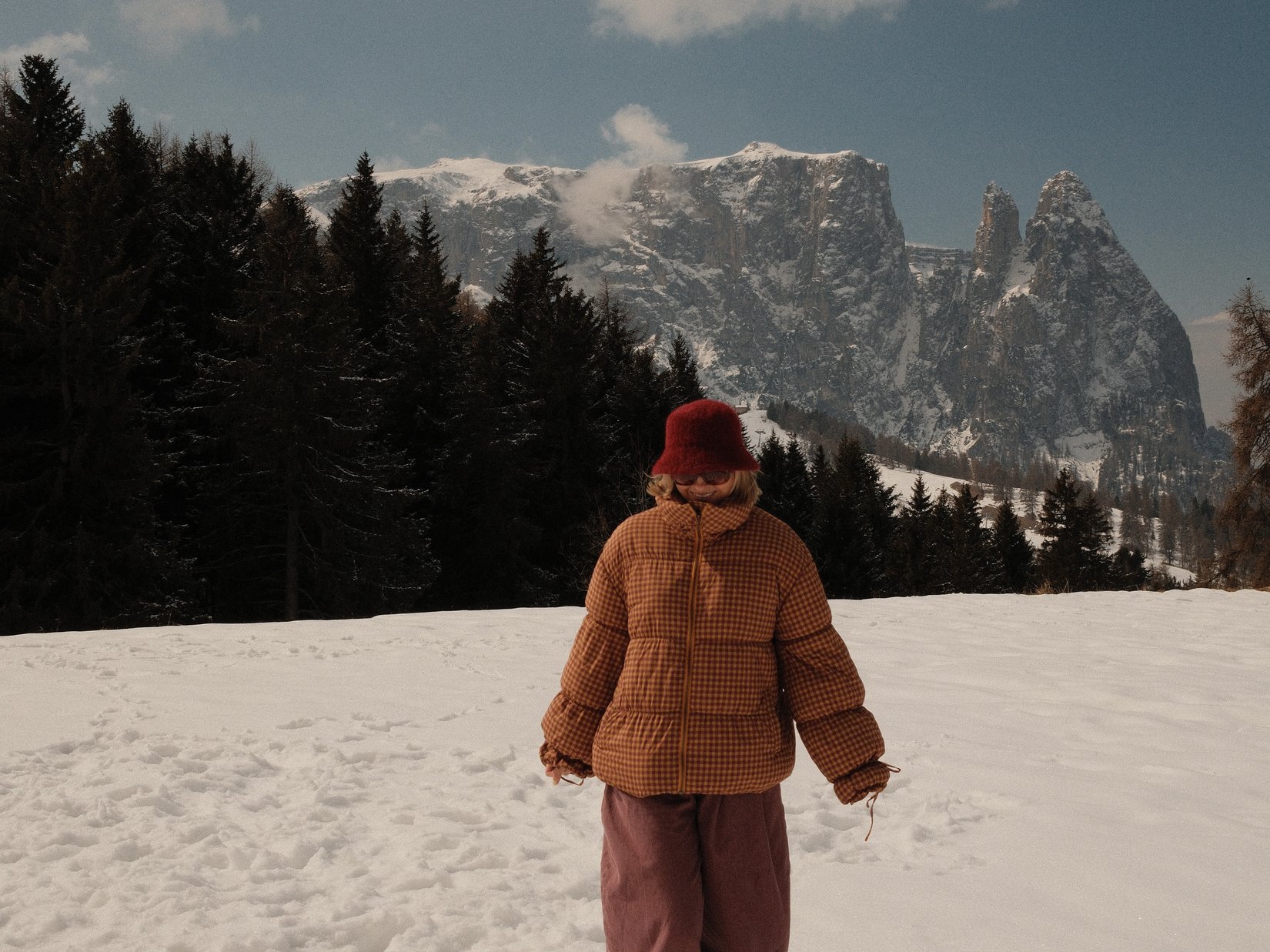 Offers – holidays in the Dolomites UNESCO World Heritage Person in winter clothes walking on snow with mountains and forest in background