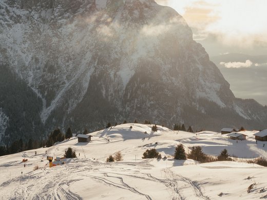 Inklusivleistungen – last minute nach Südtirol Verschneite Berglandschaft mit Skispuren und Abendsonne im Hintergrund