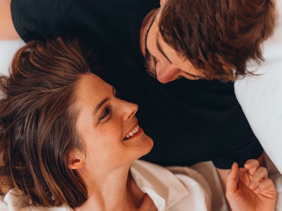 Kraftorte in Südtirol Paar liegt im Bett und schaut sich liebevoll an