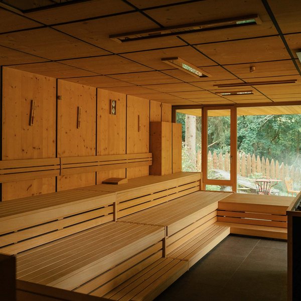 From hiking on Alpe di Siusi/Seiser Alm to the spa area Modern sauna room with wooden benches and green outdoor view