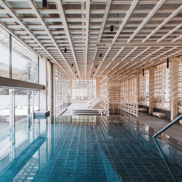 Sensoria Dolomites: il vostro hotel sull’Alpe di Siusi Interno di una piscina benessere moderna con soffitto in legno e lettini