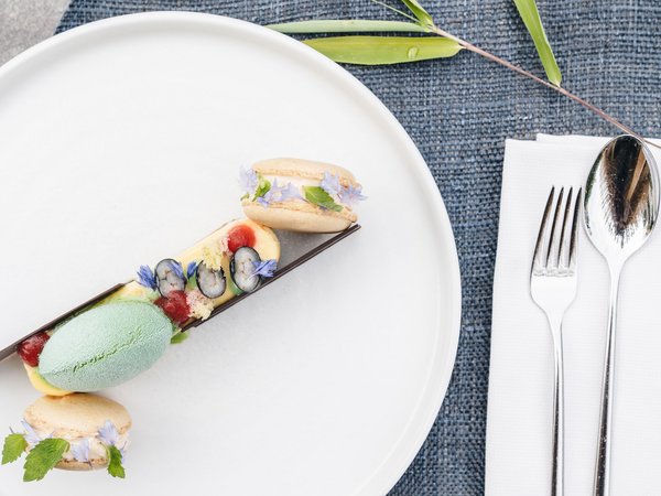 Wellness Aphrodite: Sensoria Dolomites among the winners Delicate dessert with green ice cream and decorated macarons on white plate