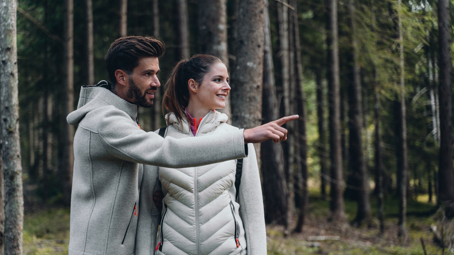 Active holidays in South Tyrol – ready for pure nature? Couple hiking in forest pointing at something