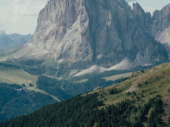 Offers – holidays in the Dolomites UNESCO World Heritage Two deck chairs facing a large mountain and forested hills