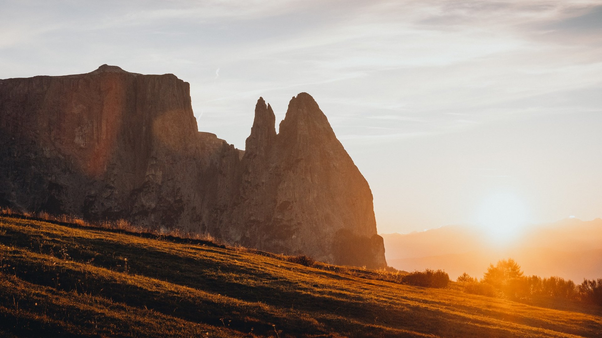 Holidays in the Dolomites – holidays at Sensoria Dolomites Sunset with orange light over mountains and grassy hillside